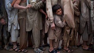 Flood survivors wait in line to recieve water relief supplies in Pabi, Pakistan.
