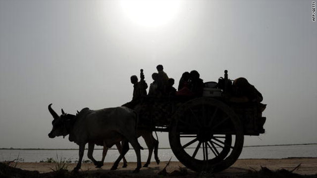 Flood-hit villagers ride and their belongings on a bullock cart on the outskirts of Sajawal, Sindh province, Pakistan on August 25