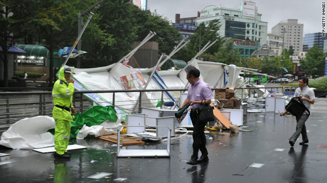 People walk past booths damaged by Typhoon Kompasu in Seoul, South Korea, on Thursday.