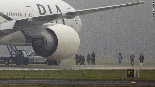 Anti-terrorist police secure a passenger as a Pakistan International Airlines Boeing 777 is evacuated at Stockholm airport.