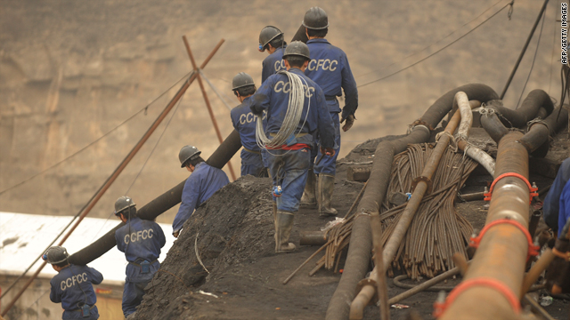 Mine workers carry pipes to the entrance to the Wangjialing coal mine during rescue efforts on March 31.