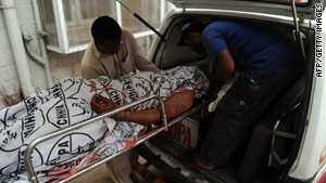 Pakistani volunteers carry an unidentified body to a hospital in Karachi after Tuesday's attack.