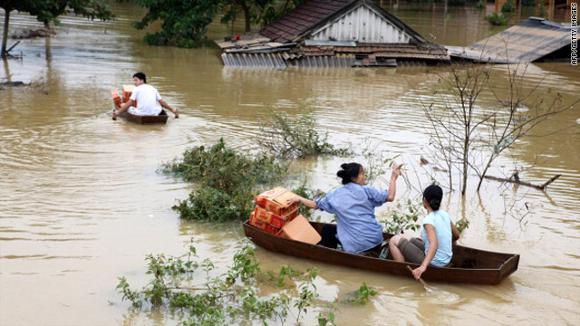 Villagers make their way home on 18 October on small boats with boxes of instant noodles received from a relief aid team at a flooded village in Huong Khe district, central province of Ha Tinh.