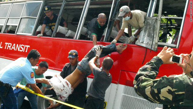 Police remove a passenger from a bus after an explosion on the Philippines southern island of Mindanao on October 21, 2010.