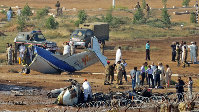 Pakistani rescuers and airport security personnel gather at an aircraft crash site in Karachi on November 5, 2010.
