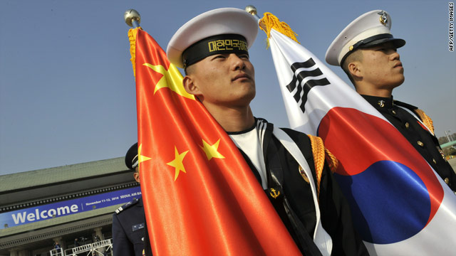 Guards carry the Chinese and South Korean flags at the G-20 but many wonder about the extent of Beijing's ambiitions.