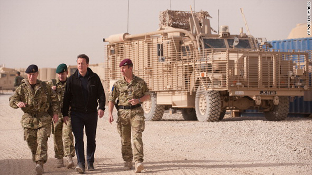 British Prime Minister David Cameron, third left, walks past a Mastiff armoured vehicle as he walks through Patrol Base 2 between Lashkar Gah and Gereshk in Afghanistan on Monday.