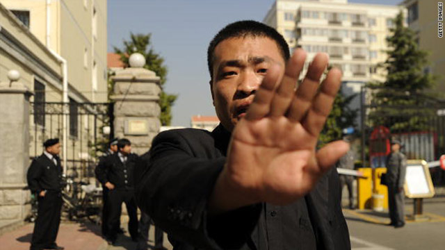 A policeman tries to stop photos being taken outside the house of the wife of jailed Chinese Nobel Peace Prize Laureate, Liu Xiaobo, in Beijing on October 13.
