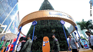 Members of a bomb squad unit patrol past a giant Christmas tree displayed in Bangkok on Tuesday.