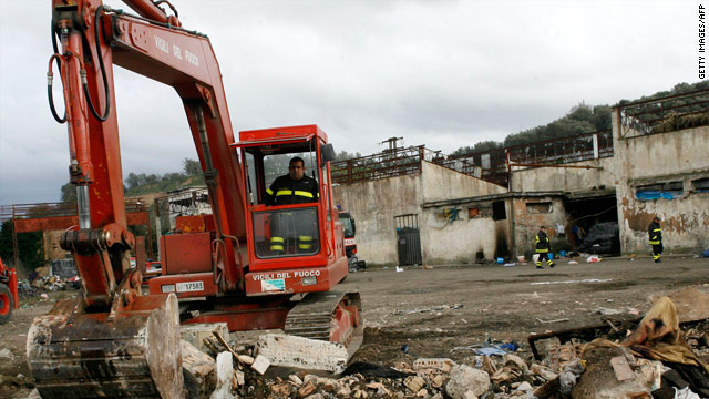 Firemen on Monday pull down a factory where immigrant workers were living in Rosarno, Italy.