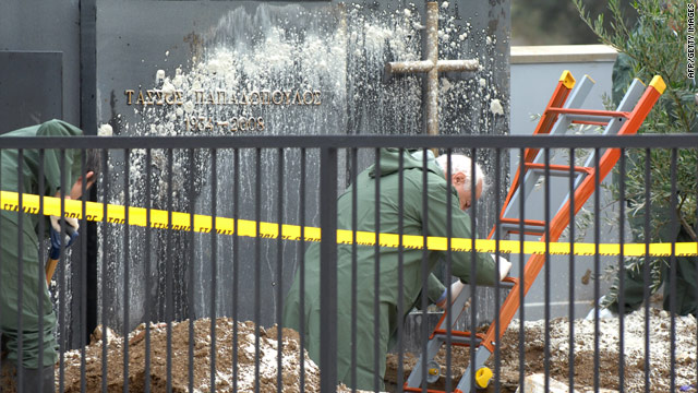 Forensic experts inspect the dug-out grave of Tassos Papadopoulos on the outskirts of Nicosia in October 2009.