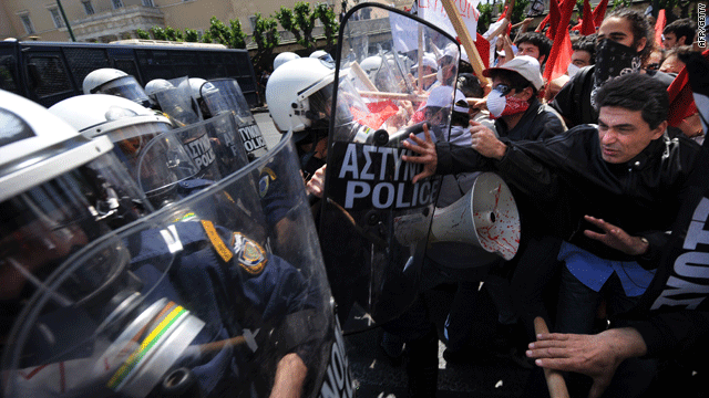 Greek workers protesting against the government attack riot police on Tuesday in Athens with sticks and plastic bottles.