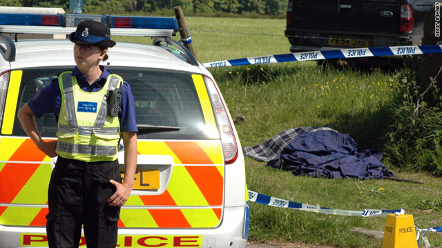 A police woman stands guard beside a body near Seascale after a gunman killed at least 12 people.