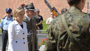 Secretary of State Hillary Clinton pauses to honor murdered military officers Saturday in Krakow, Poland.