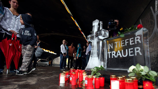 People pay their respects on Monday in front of a make-shift memorial to the festival goers who died in a stampede on Saturday.