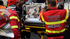 Emergency workers evacuate an infant injured in a hospital fire on August 16, 2010.