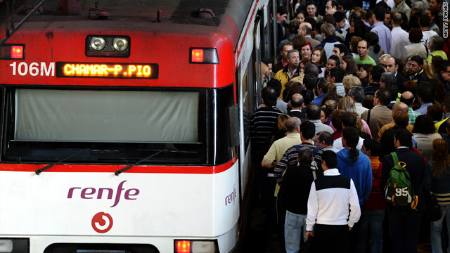 Commuters attempt to board a commuter train operating on a skeleton service in Madrid, Spain, on Wednesday.