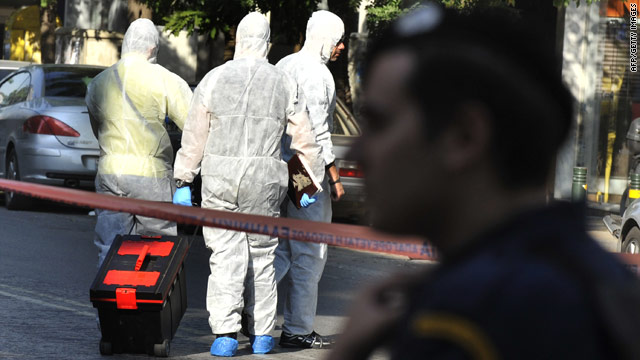 Police investigators collect evidence at the offices of a courier company in Athens on November 1.