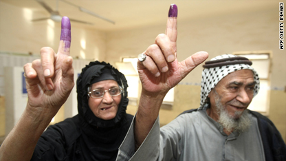 Iraqis holding up their ink-stained index fingers to show they have voted.