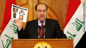 Iraqi Prime Minister Nuri al-Maliki displays a photo of the body of Abu Omar al-Baghdadi.