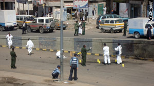 Officers inspect the scene of a bomb attack Monday on the British ambassador to Yemen.