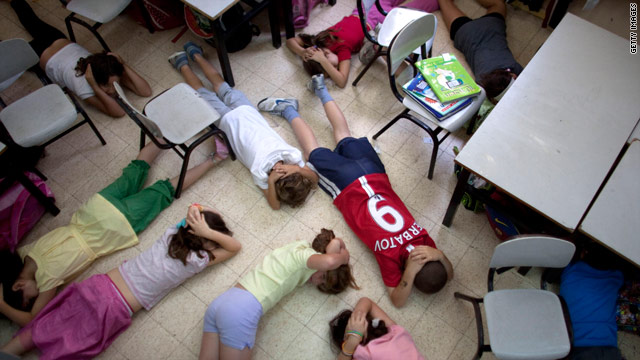 School children in Tel Aviv take cover during a nationwide drill in May to prepare the public for an emergency situation.