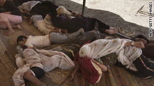 Bedouin women and children sleep in the shade after being escorted from their village.