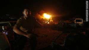A Palestinian man shouts as flames from Israeli airstrikes burn in Gaza City late Friday.