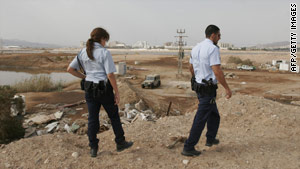 Israeli police inspect the site where a rocket reportedly landed on the outskirts of Eilat.