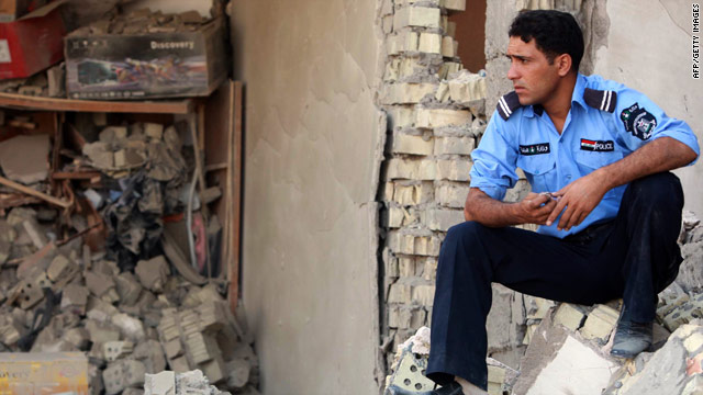 A police officer surveys rubble in Karbala, south of Baghdad. Militants launched a wave of
bombings Wednesday across Iraq.