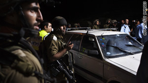 Israeli soldiers inspect a settlers' car after it was ambushed by Palestinian gunmen in the southern West Bank Tuesday.