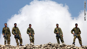 Israeli soldiers stand guard on the road leading to the Jewish settlement of Kiryat Arba in the West Bank.