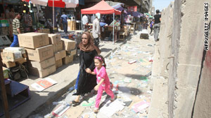 A mother and child run Sunday after a suicide bombing at Iraqi military headquarters in central Baghdad.