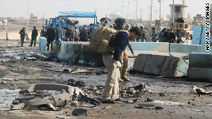 Iraqi security forces survey the scene of a suicide attack in Ramadi,