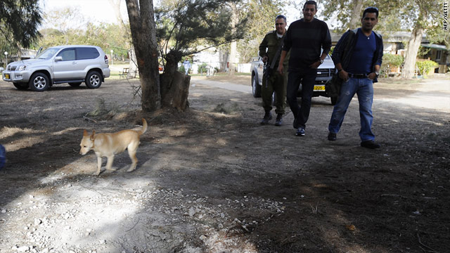 Israeli security officers look at the site December 21 where a rocket fired from Gaza landed in Kibbutz Zikim, southern Israel.