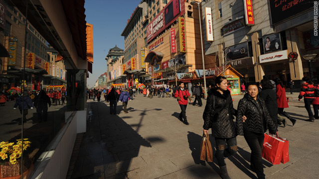 Shoppers walk through a busy retail street in Beijing as China overtakes Japan in terms of GDP.