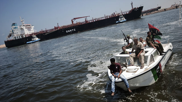Small boats of Libyan rebels escort an oil tanker, laden with 73,000 tons of petrol, as it docks in the Benghazi harbor on August 5.