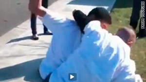 A still from a YouTube video shows two minors fighting in the front yard of Jennifer Zuniga, police say.