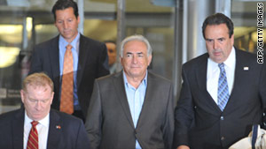 Former IMF head Dominique Strauss-Kahn leaves a New York building under guard on Wednesday.