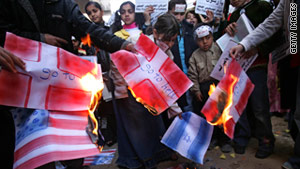 Protesters burn the Danish flag. Tahawwur Hussain Rana was found guilty of aiding a plot against a Danish paper.