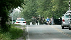 Law enforcement officers investigate Sunday after a gunman shot to death seven people in Copley Township, Ohio.