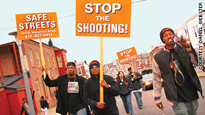 Tard Carter, right, leads a rally after a shooting in Baltimore.