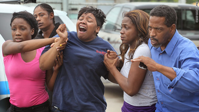 Bystanders react to police finding two teens' bodies near the railroad tracks in Chicago's Princeton Park community last year.