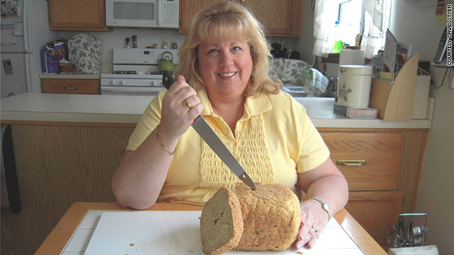 Denise Swanson, author of the Scumble River mysteries, slashes into a loaf of homemade bread.