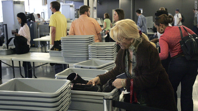 An air traveler places some of her belongings into a bin at a security checkpoint at O'Hare International Airport in Chicago.