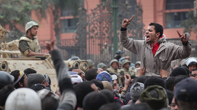 An anti-government protester chants and gestures in front of soldiers guarding the Egyptian Museum in Tahrir Square.