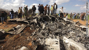 People gather at the wreckage of a U.S. F-15 fighter jet, southeast of Benghazi, Libya, on March 22, 2011.