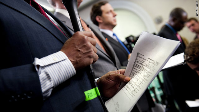 Televison news correspondents hold copies of U.S. President Barack Obama's long-form birth certificate at the White House.