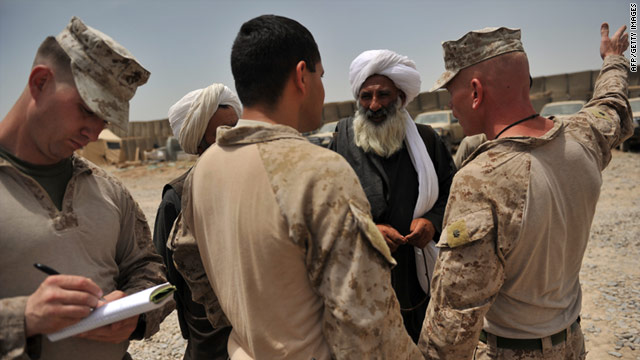 Marine Lt. Col. John Harril talks to a leader in Helmand province, Afghanistan, as 1st Lt. Jake Freeman takes notes.