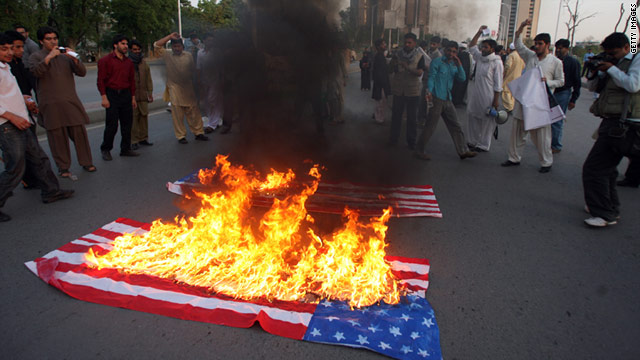 Pakistani Shiite students gather around burning U.S. flags during a protest in Islamabad on March 20.